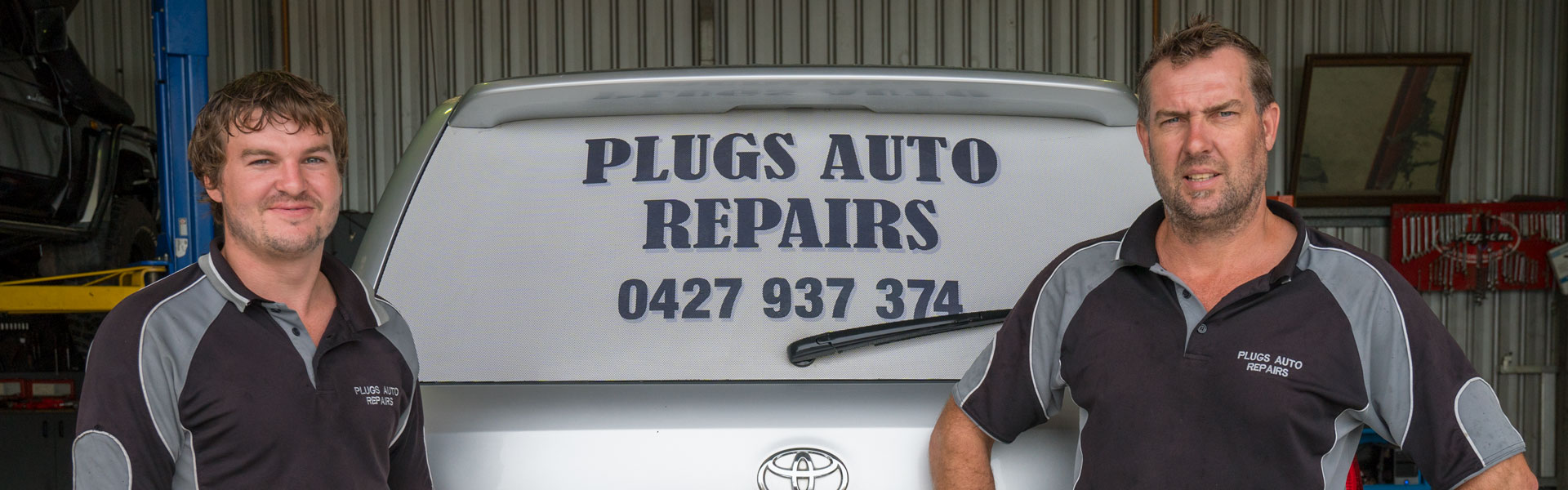Plug's Auto Repairs team beside a workshop vehicle